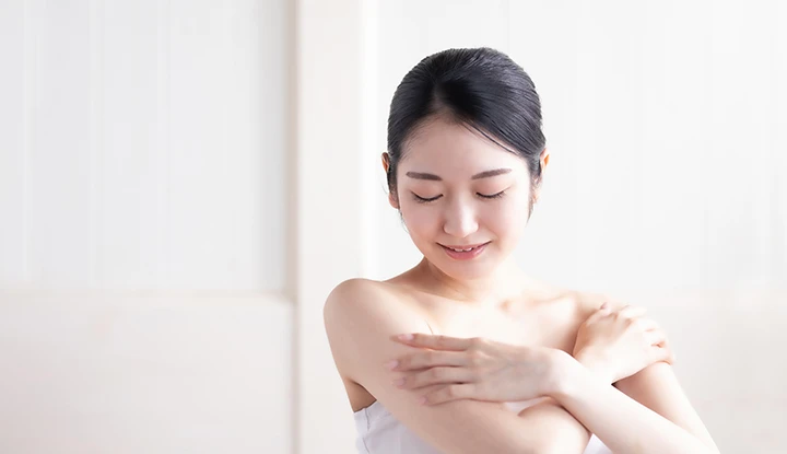 女性が腕を触っている